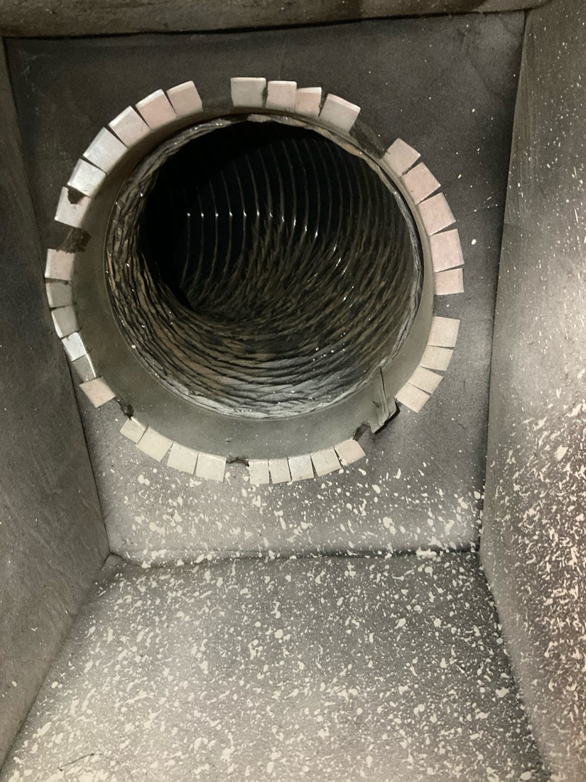 Cleaned duct opening with white sealing tape visible around the perimeter.