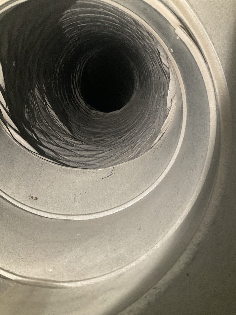 Interior of ductwork after cleaning, spiral grooves visible inside round duct.