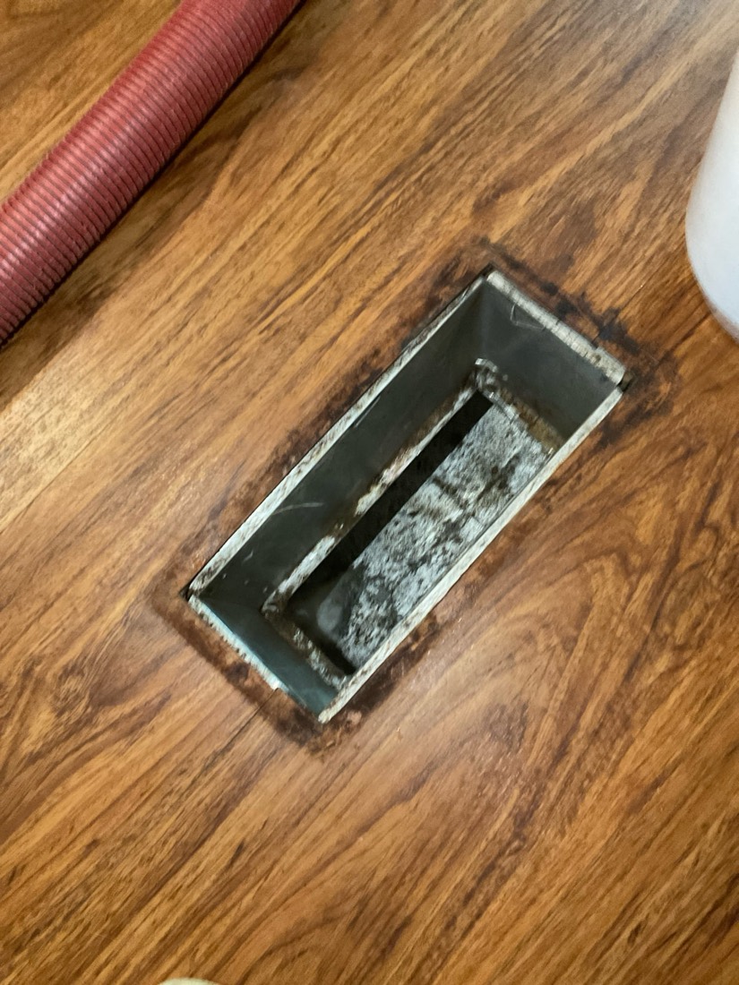 Clean air duct register showing removed debris and dust buildup.