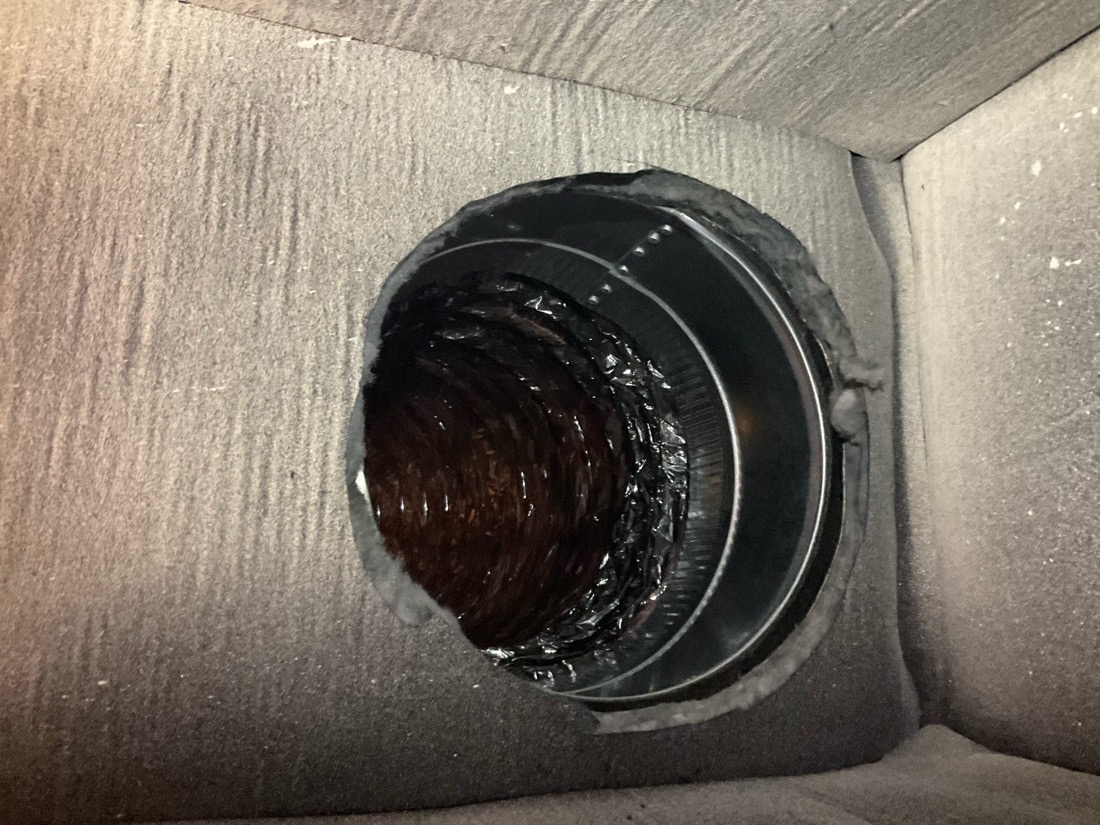 Cleaned circular duct opening showing metal interior tubing after duct cleaning service.