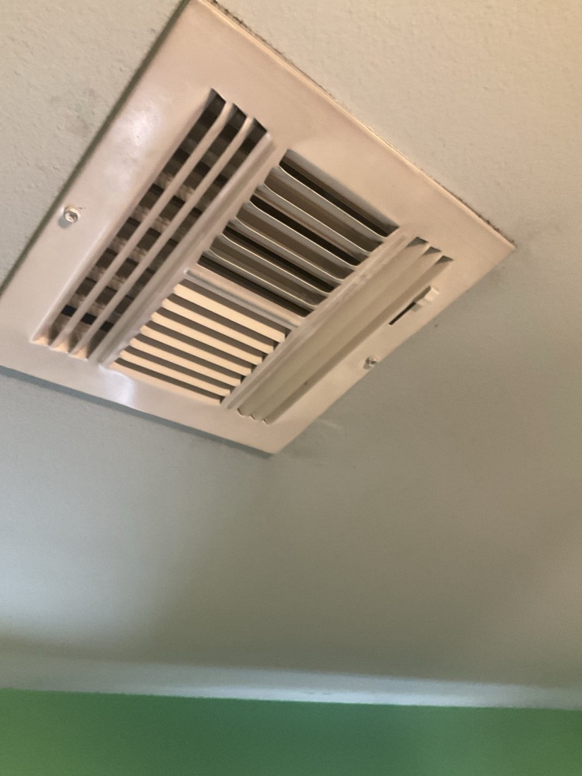 Clean ceiling-mounted air return vent with visible vanes