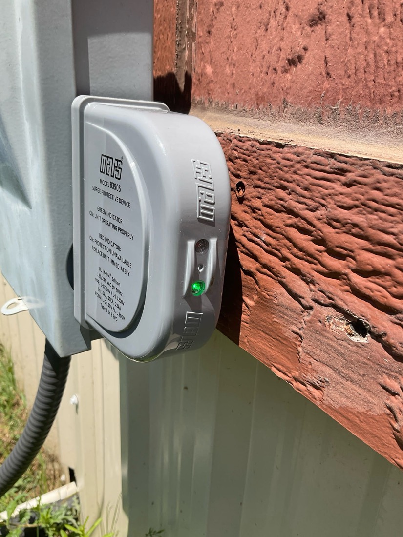 White HVAC outlet mounted on exterior wall with brick background