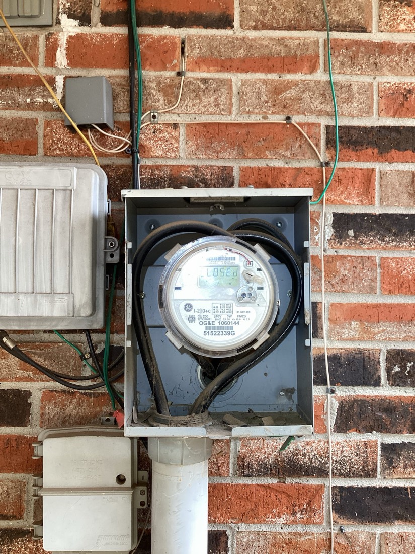Utility meter mounted on red brick exterior wall