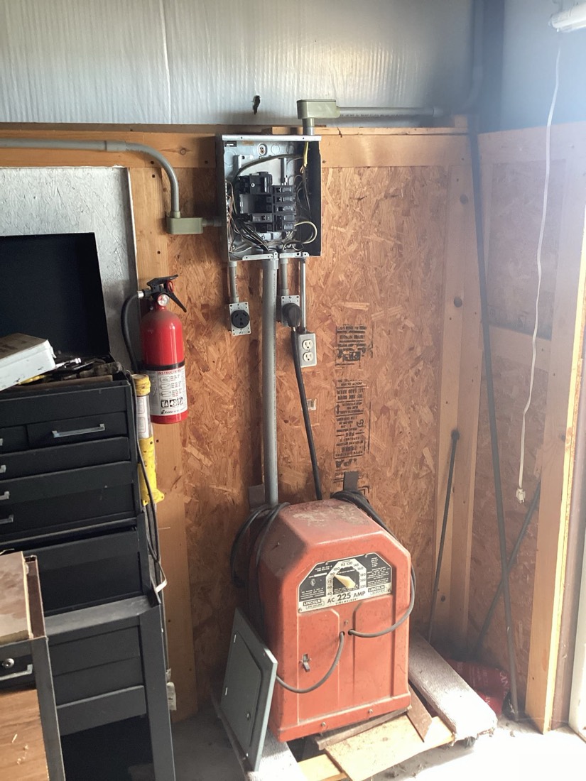 Electrical disconnect switch and charging equipment mounted on wooden wall in shelter