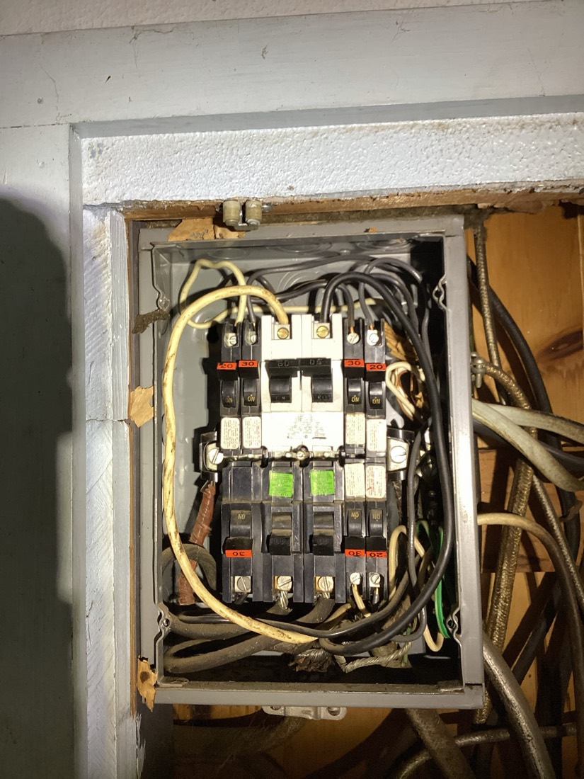Electrical service panel with organized yellow and black wiring.