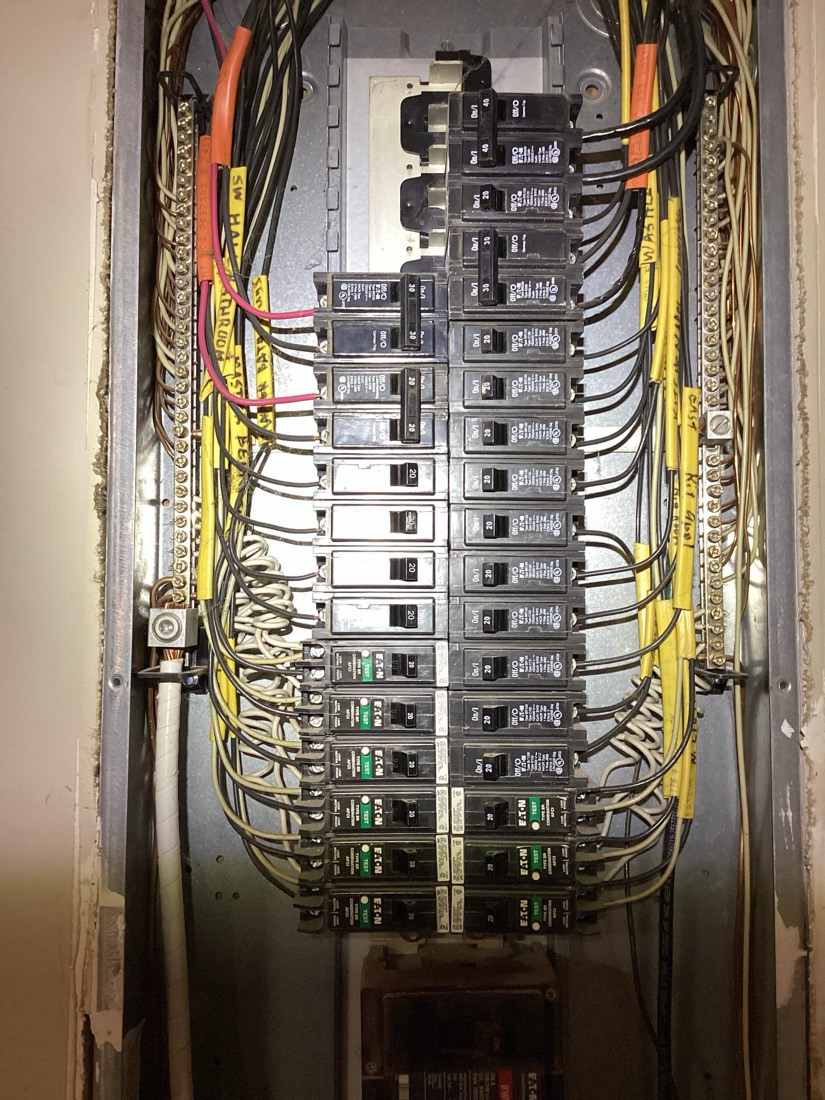 Clean electrical panel with organized circuit breakers and color-coded wiring runs
