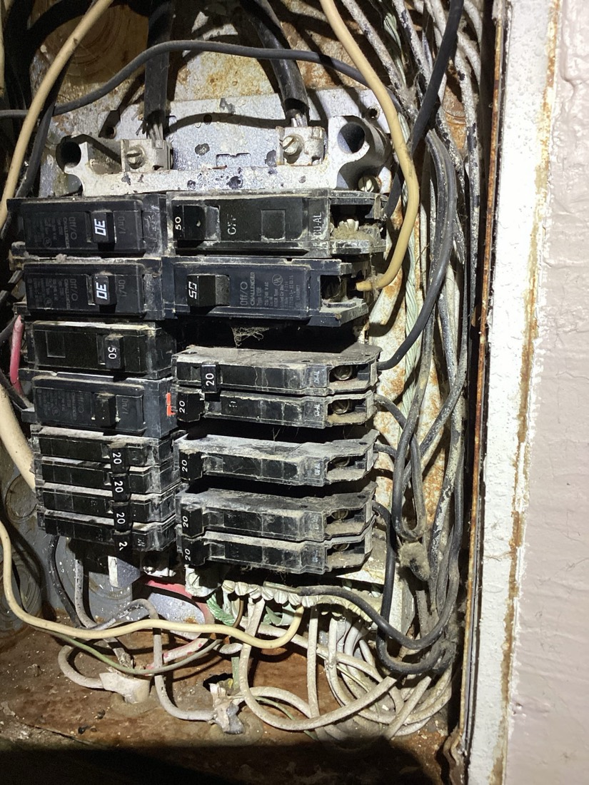 Electrical circuit breaker panel with organized wiring connections.