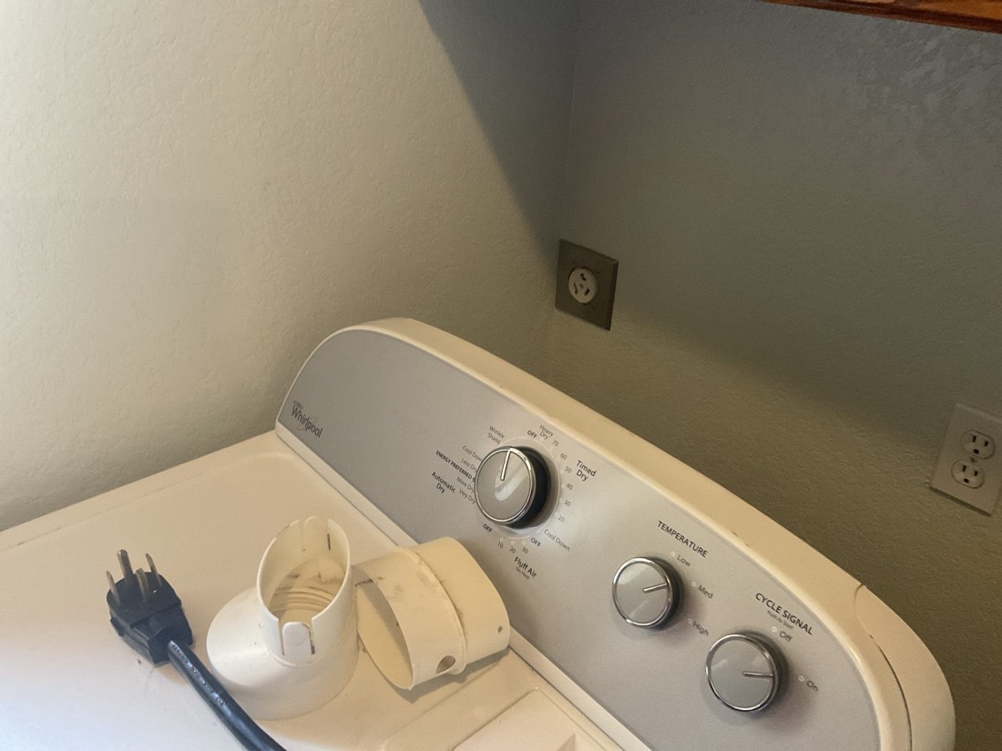 Newly installed white wall outlet with power cord nearby