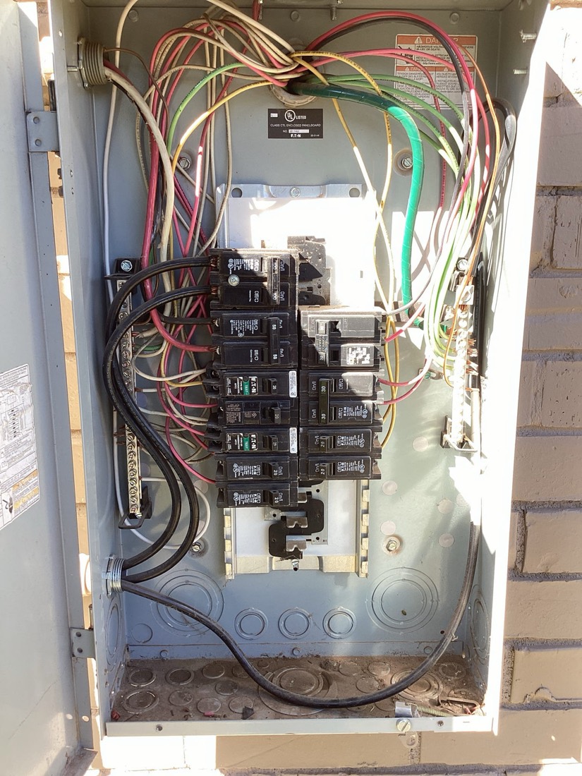 Interior electrical panel showing breakers and neatly routed red, green, and yellow wires