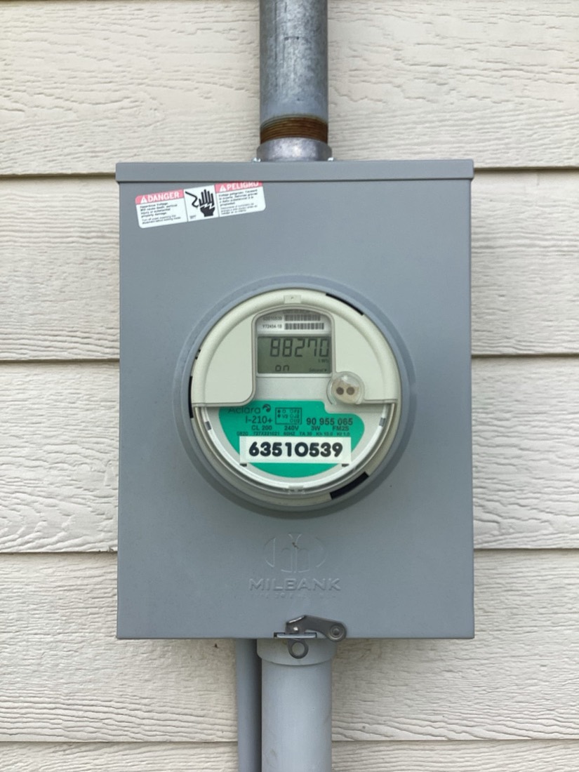 New electric meter mounted on house siding.