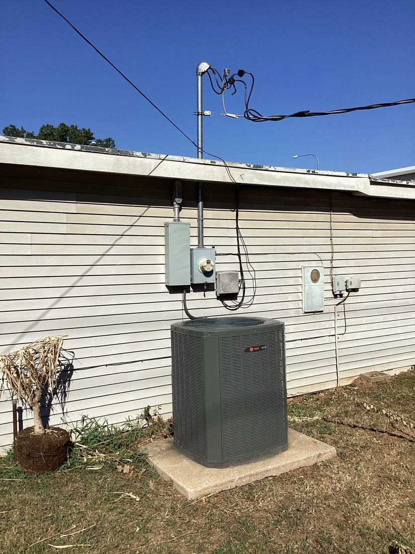 New AC unit on pad with disconnect switch and electrical conduit properly mounted and routed.