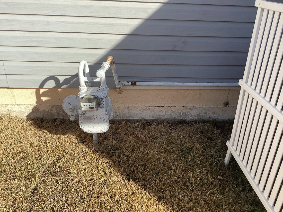 Gas meter and service equipment at residential foundation