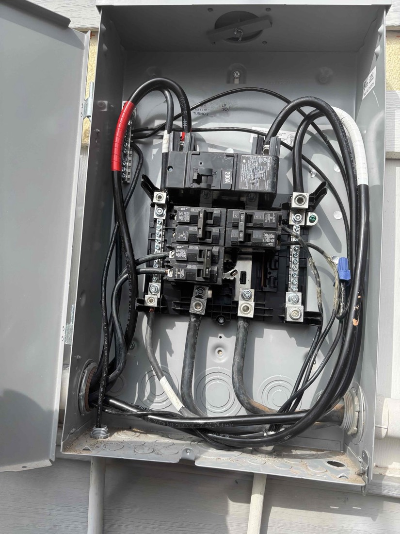 New electrical panel with breakers and wiring installed on exterior wall