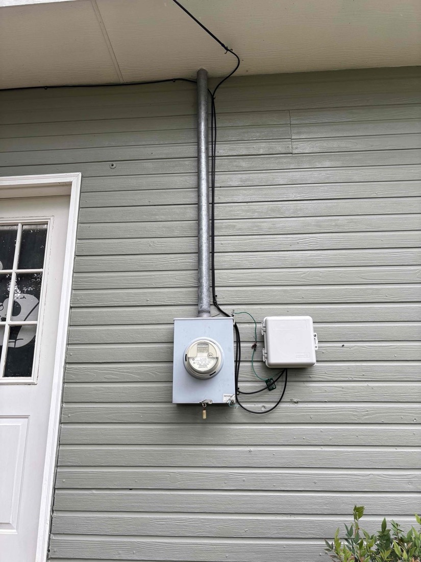 Exterior electrical meter and disconnect switch mounted on house wall.