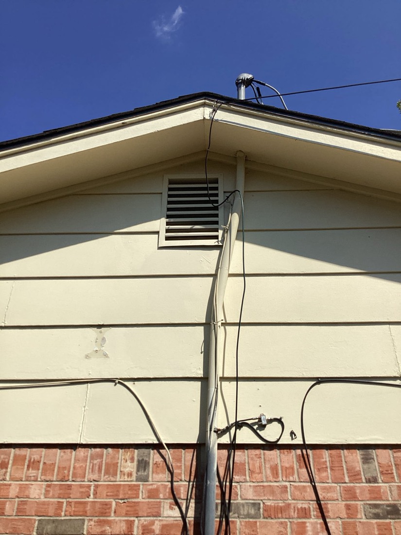 Electrical vent and conduit installed on home exterior.