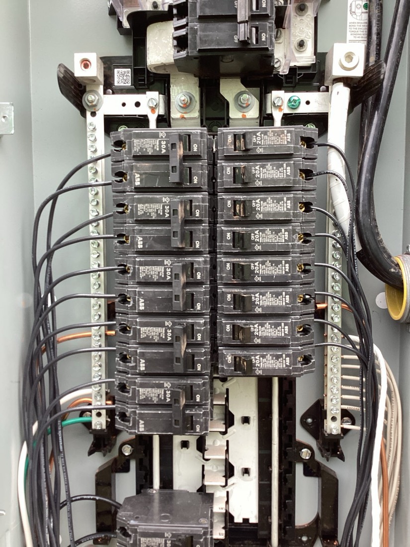 New main electrical panel with dual breaker banks and organized wiring.