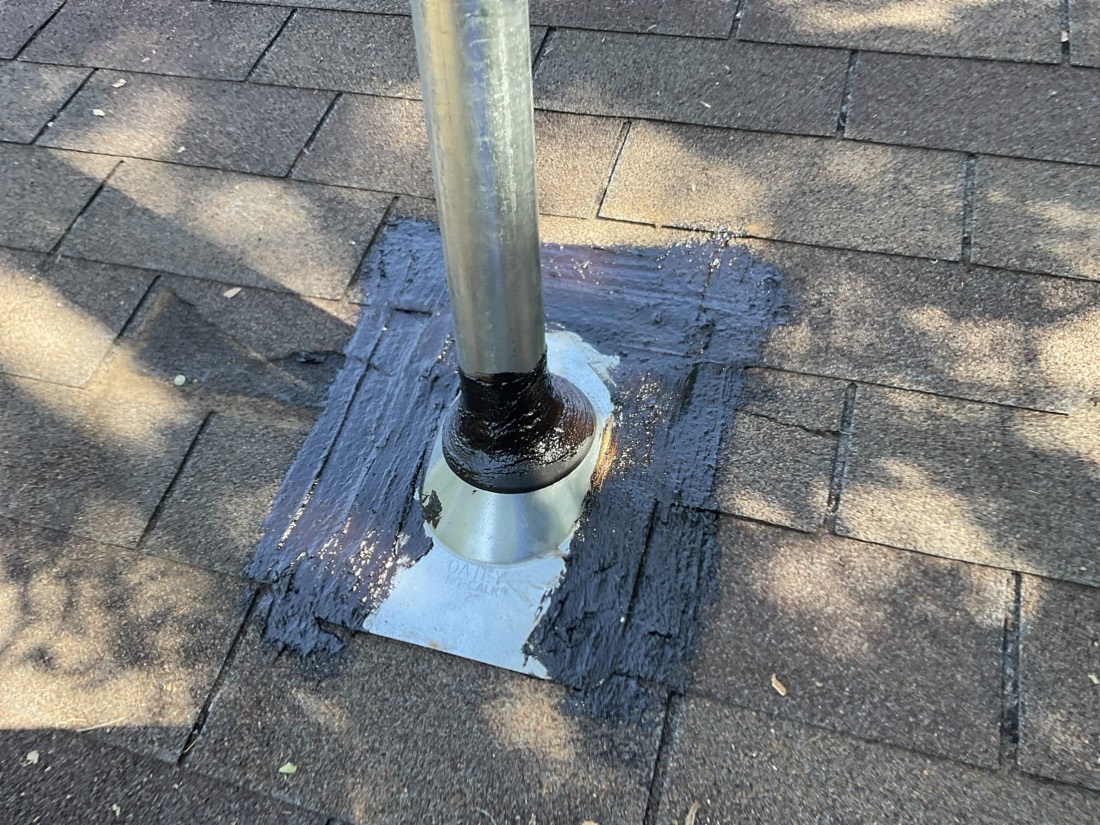 Sealed roof vent penetration with metal collar and flashing on shingle roof