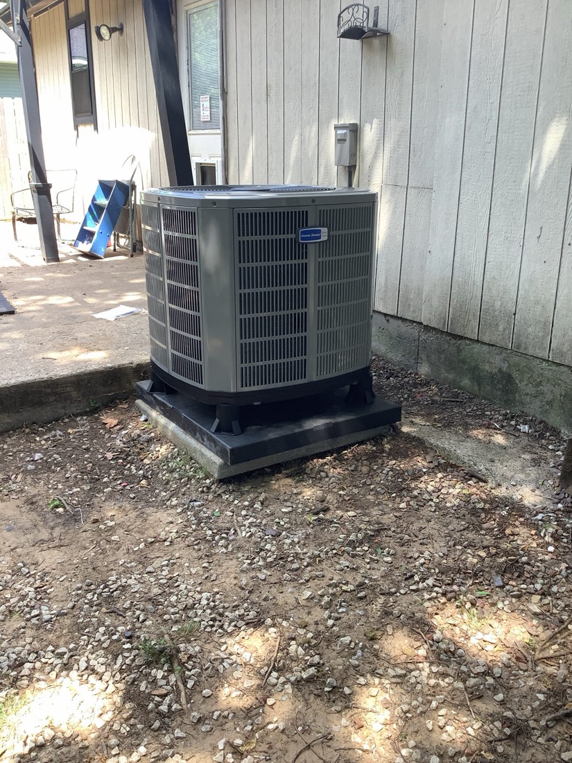 New AC condenser unit installed on concrete pad