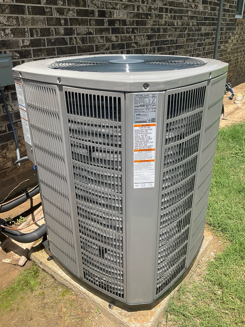 Installed AC condenser unit next to brick wall