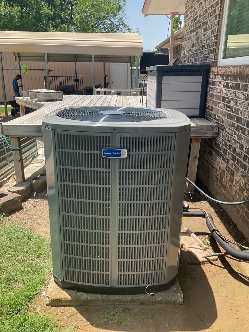 Newly installed AC condenser unit on concrete pad