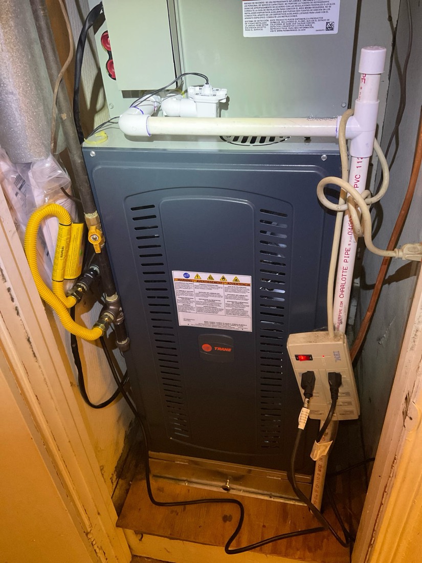Installed HVAC furnace unit with connected piping and electrical