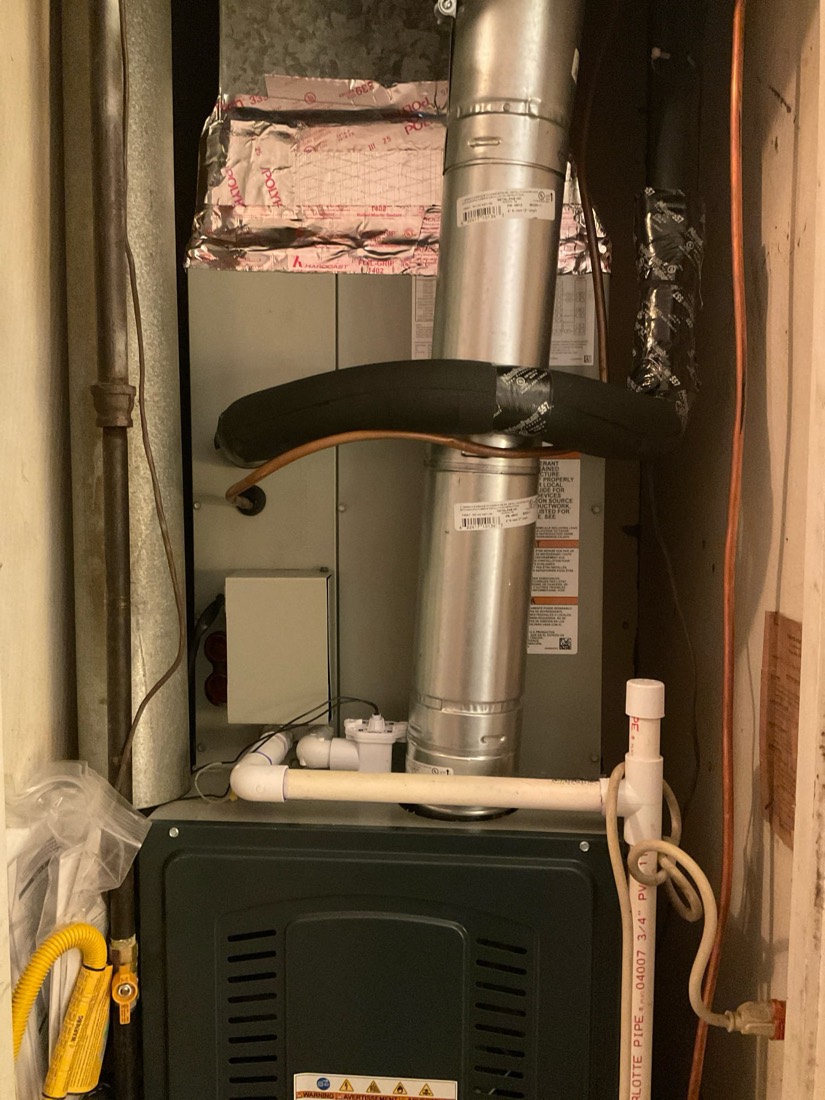 Installed furnace with water heater and ductwork in utility closet