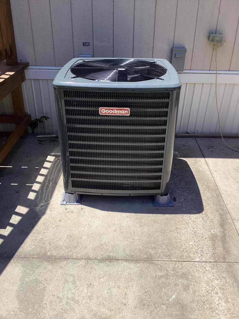 Goodman AC condenser unit on concrete pad with clear view of fan and coils