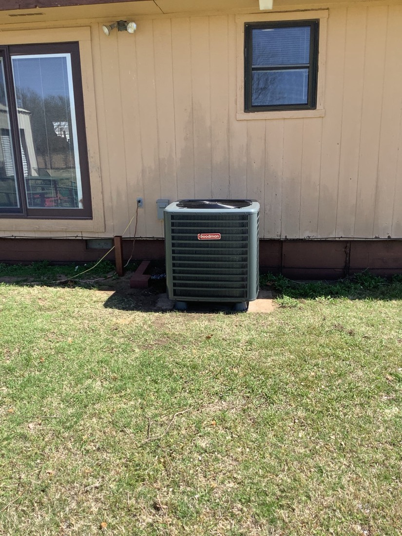 Outdoor AC unit installed on concrete pad near home