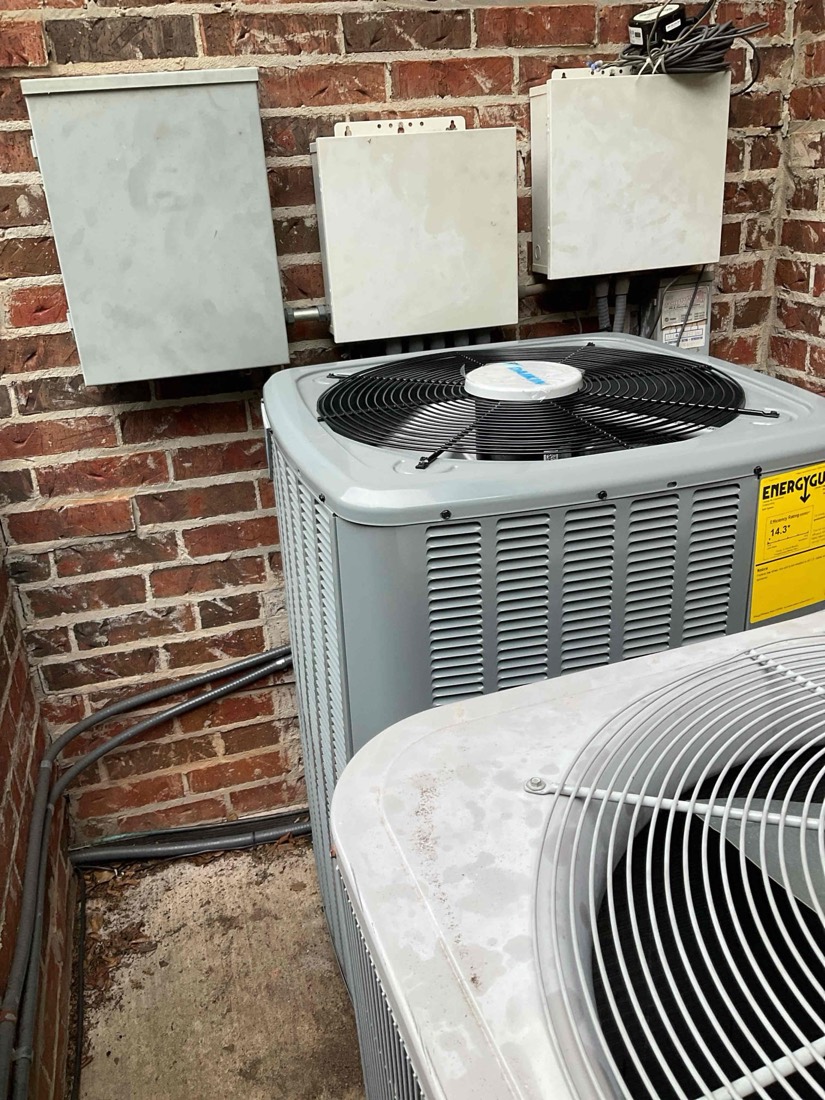 AC condenser unit mounted on exterior brick