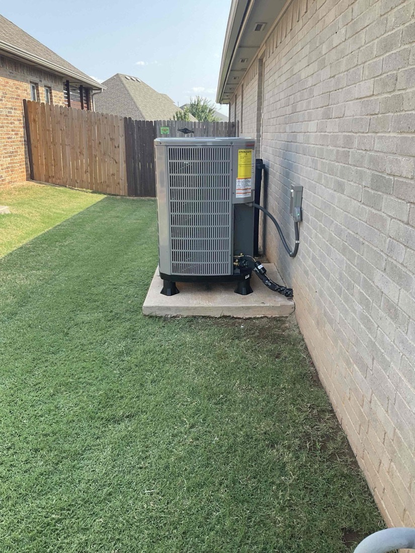 New AC condenser unit installed on concrete pad