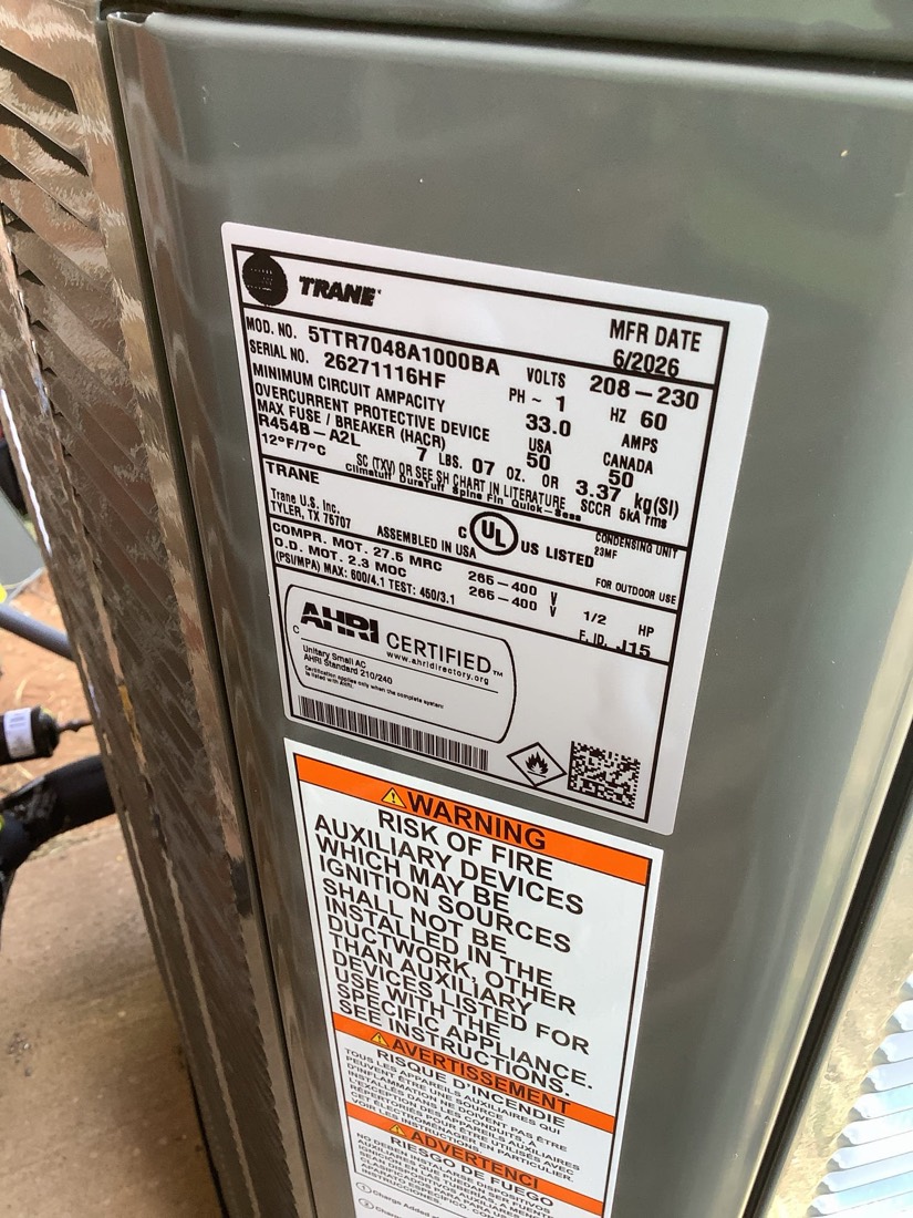 Trane furnace unit nameplate with technical specifications and safety certifications.