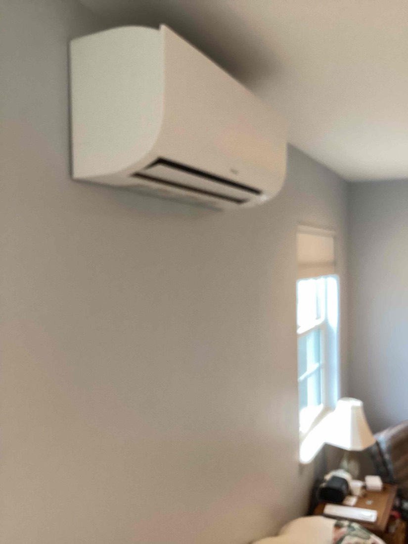 New indoor ductless AC unit installed on bedroom wall