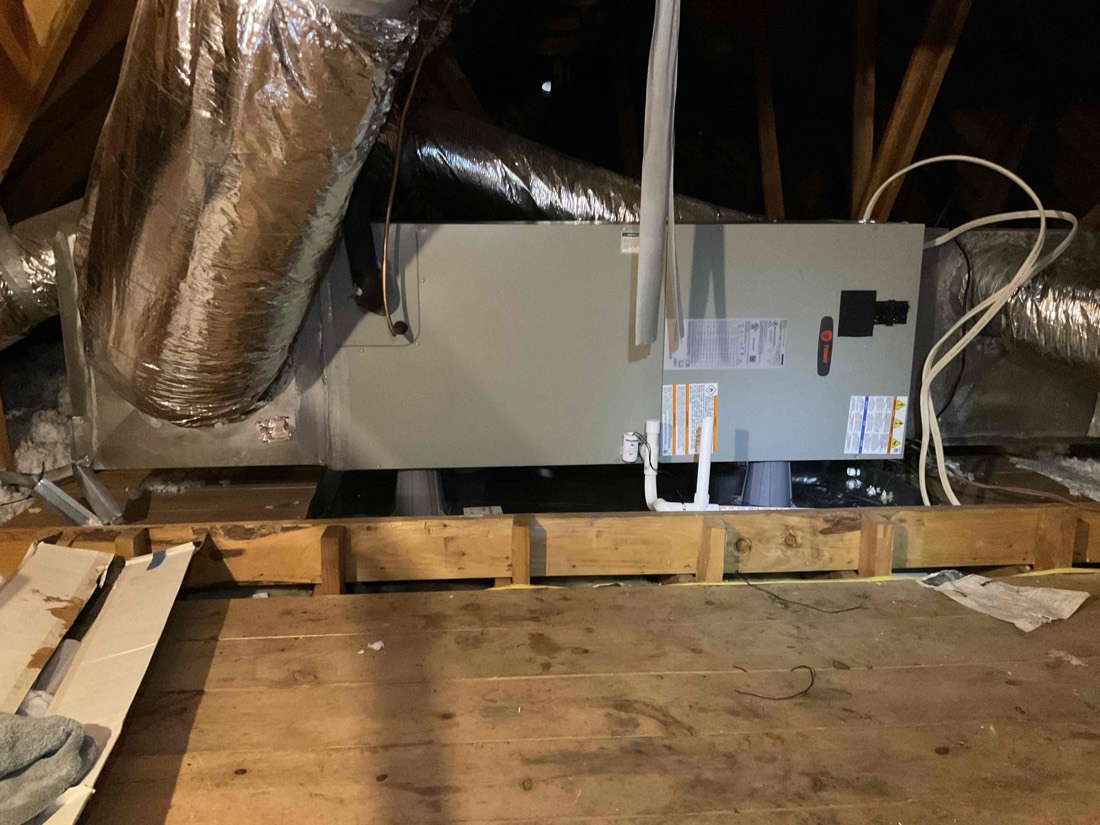 Installed air handler unit with ductwork and supply lines.