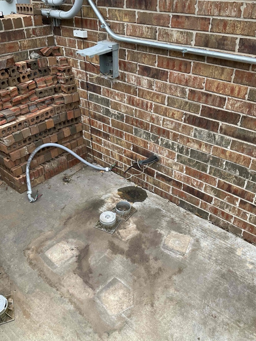 New condensate drainage line and drain pan on brick wall.
