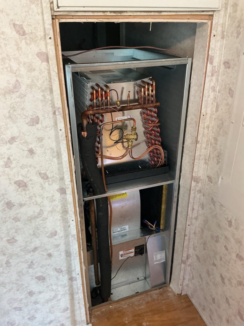 Dual-system HVAC installation showing cooler and air handler unit in closet.