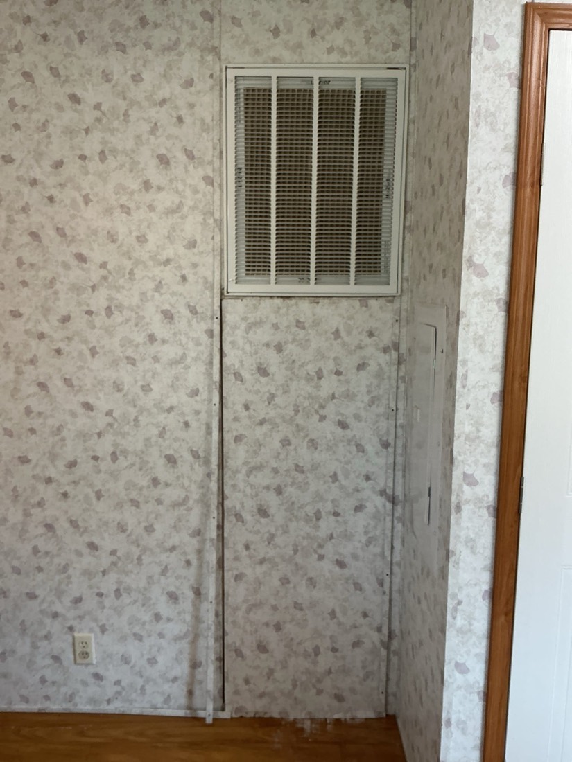 Evaporative cooler unit mounted in closet with intake ductwork visible above.