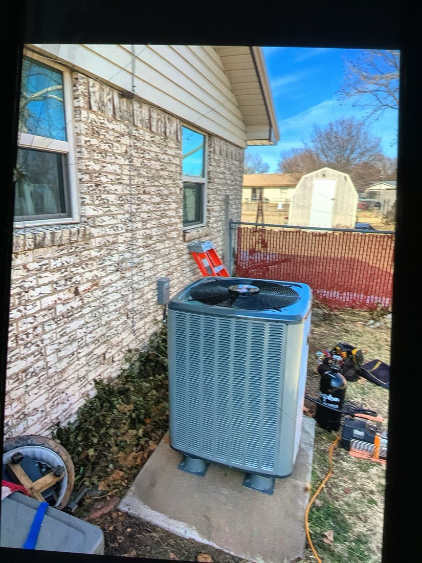 Installed AC condenser unit at residential home exterior.
