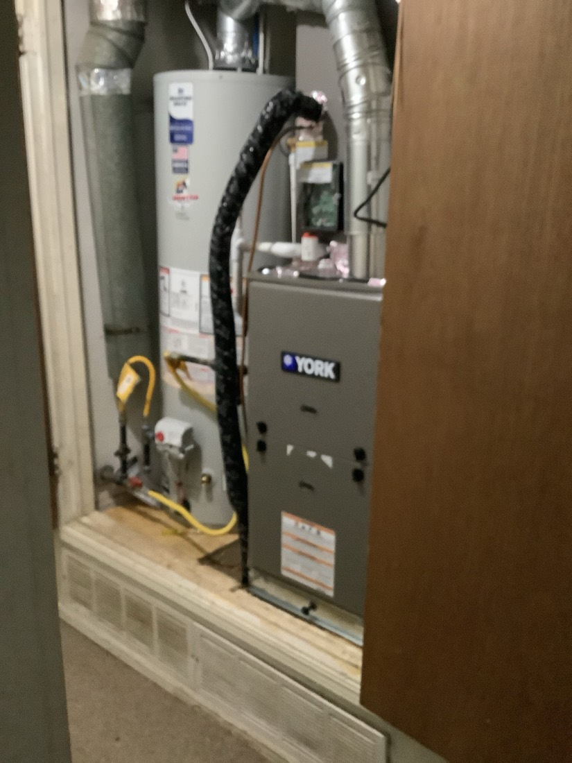 Installed York furnace with white water heater and connected ductwork.