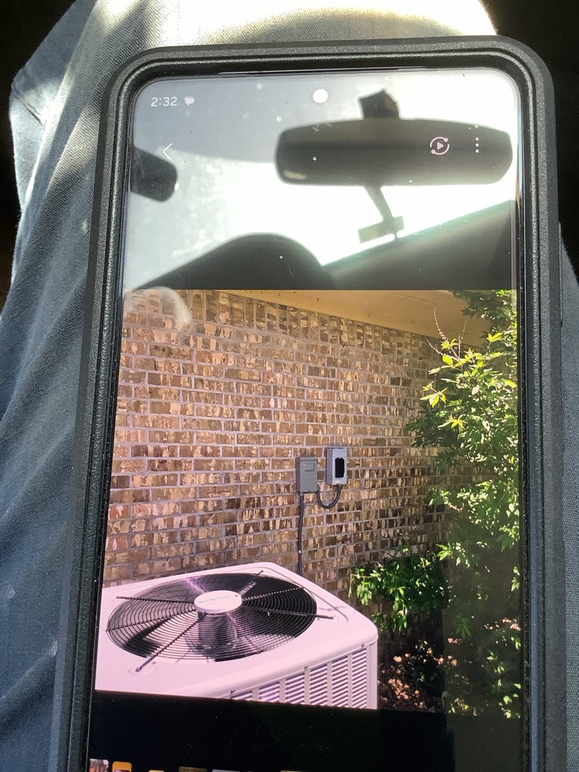 Installed AC outdoor unit in residential setting with brick wall