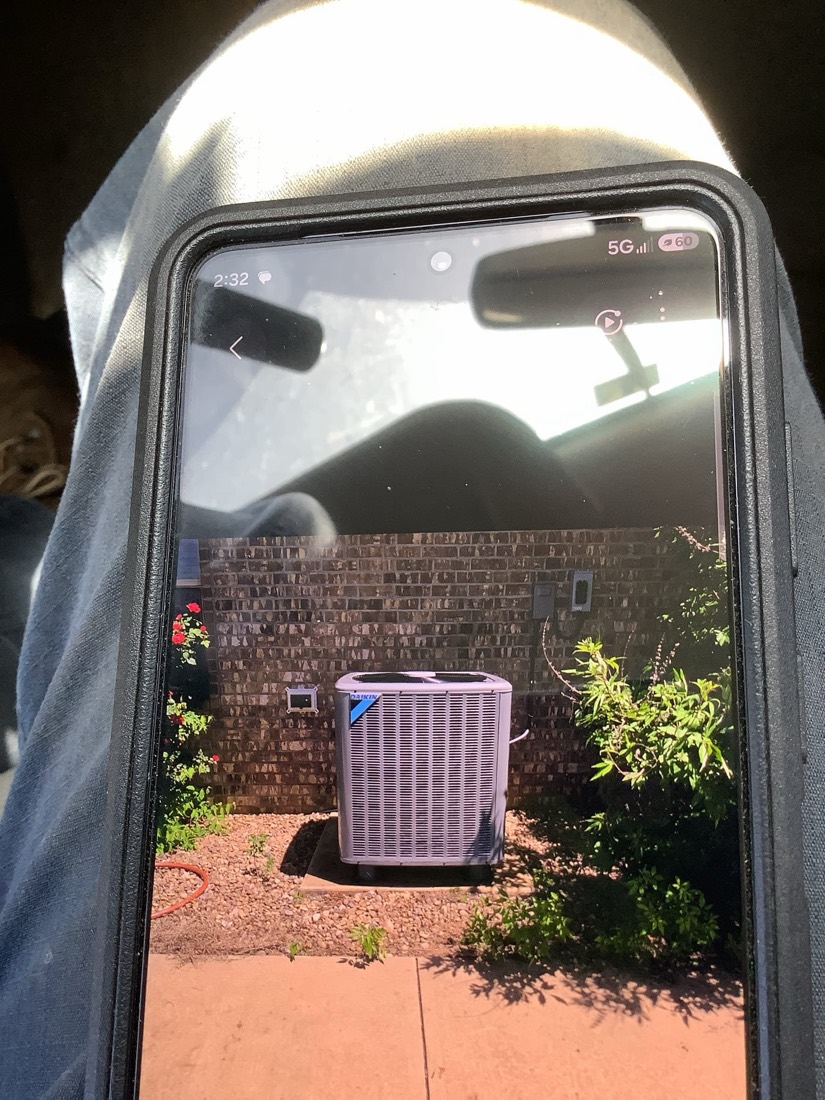 New air conditioning condenser unit installed outside brick house