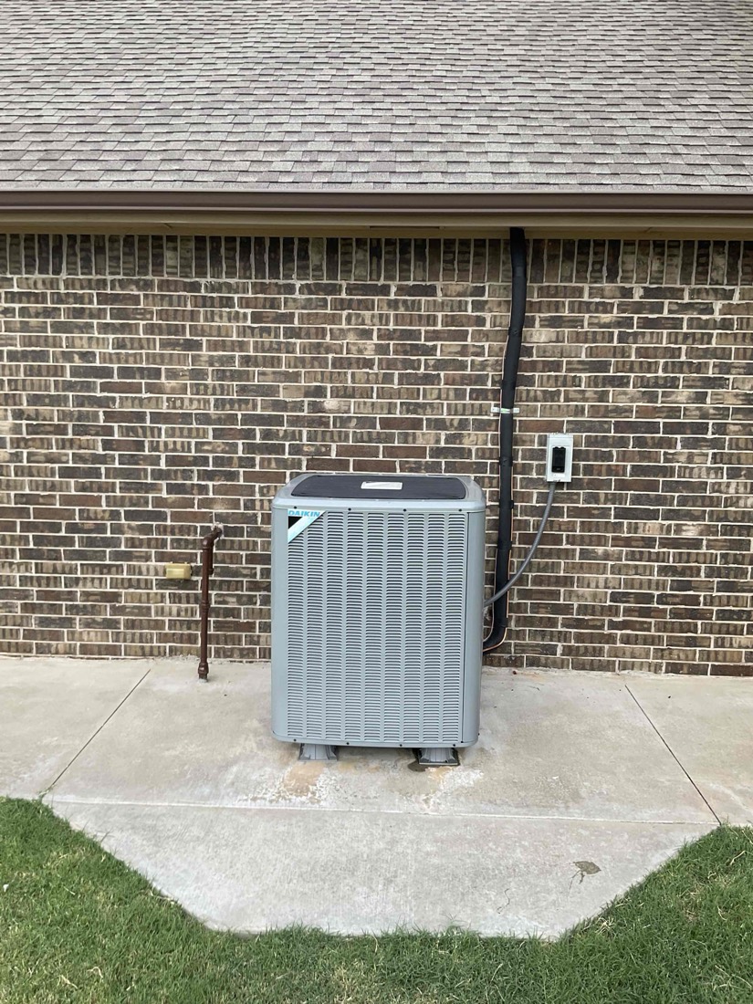 Newly installed air conditioning condenser unit mounted on concrete pad