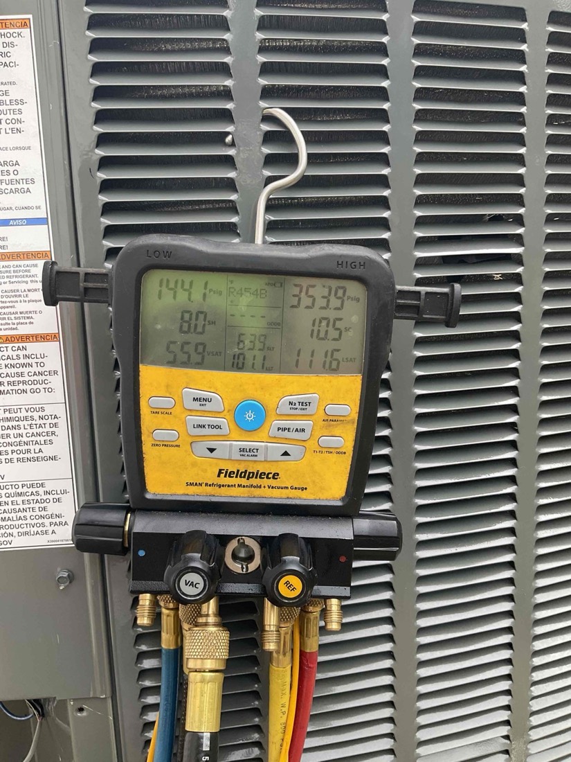 Fieldpiece diagnostic gauge showing refrigerant pressure and temperature readings.