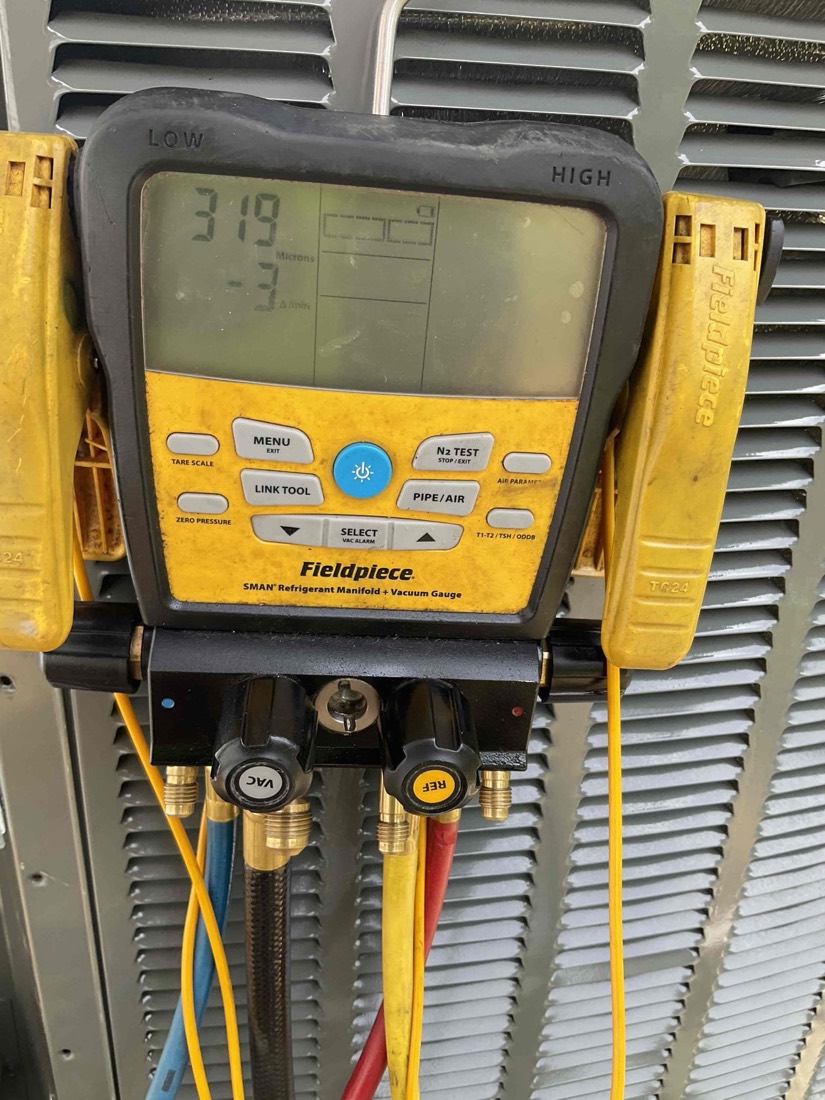 Fieldpiece manifold gauge set displaying refrigerant pressure readings.