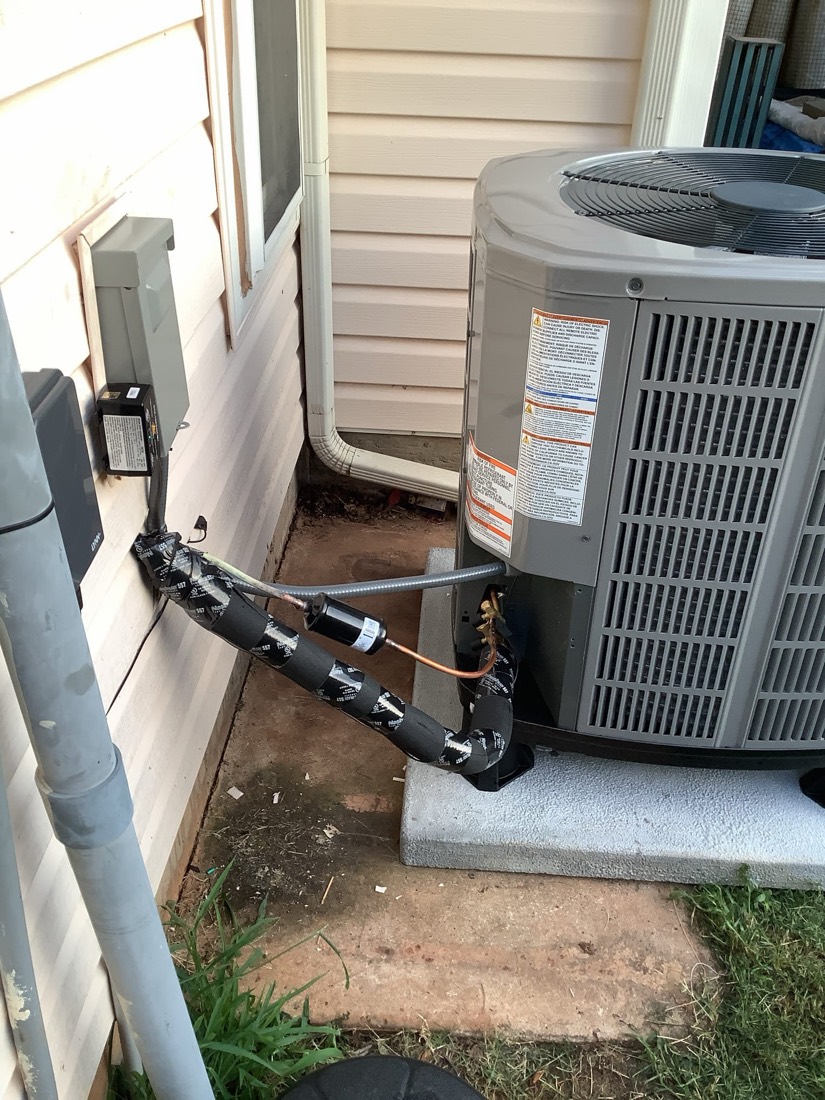 Installed air conditioning unit with refrigerant tubing connections