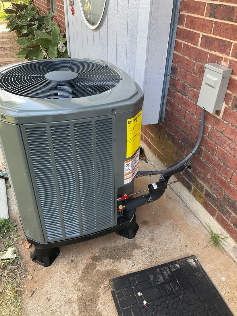 Installed air conditioning condenser with refrigerant lines and electrical connections