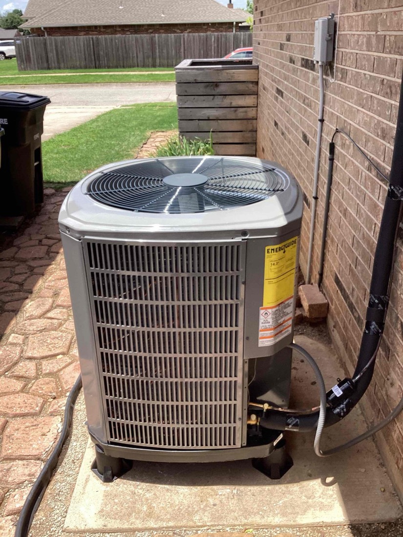 AC condenser unit installed on concrete foundation