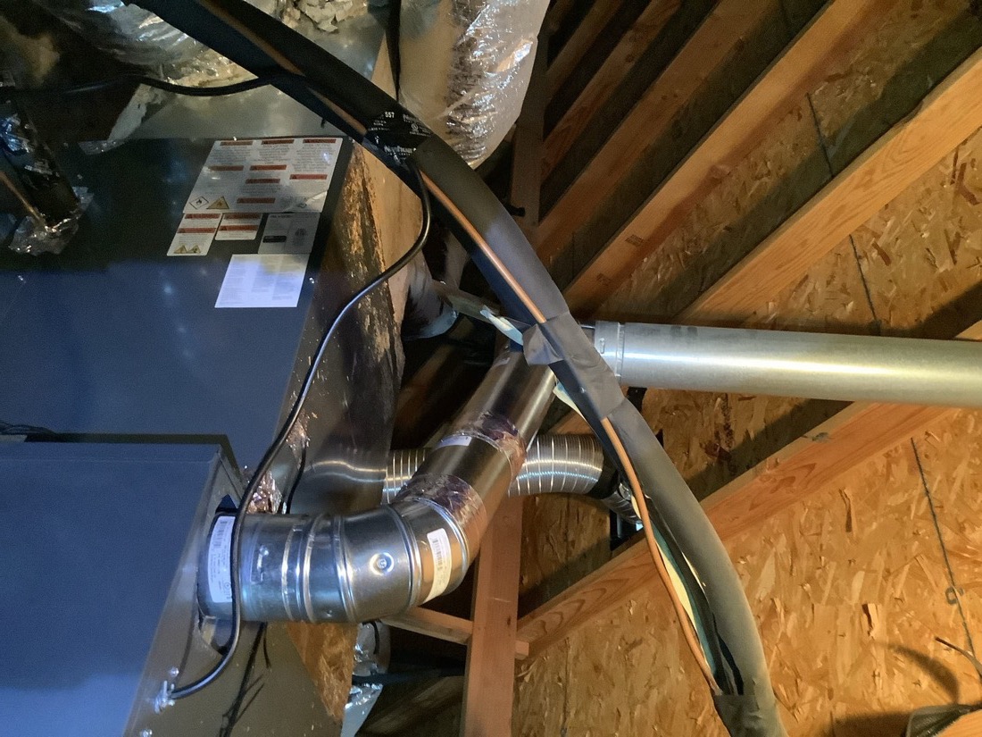 Installed HVAC air handler with ductwork connections in attic space