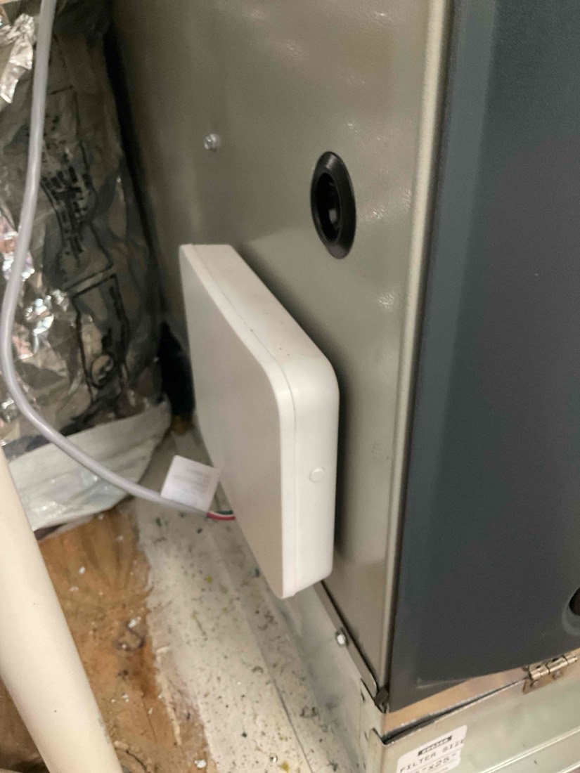 White humidifier device mounted on furnace unit