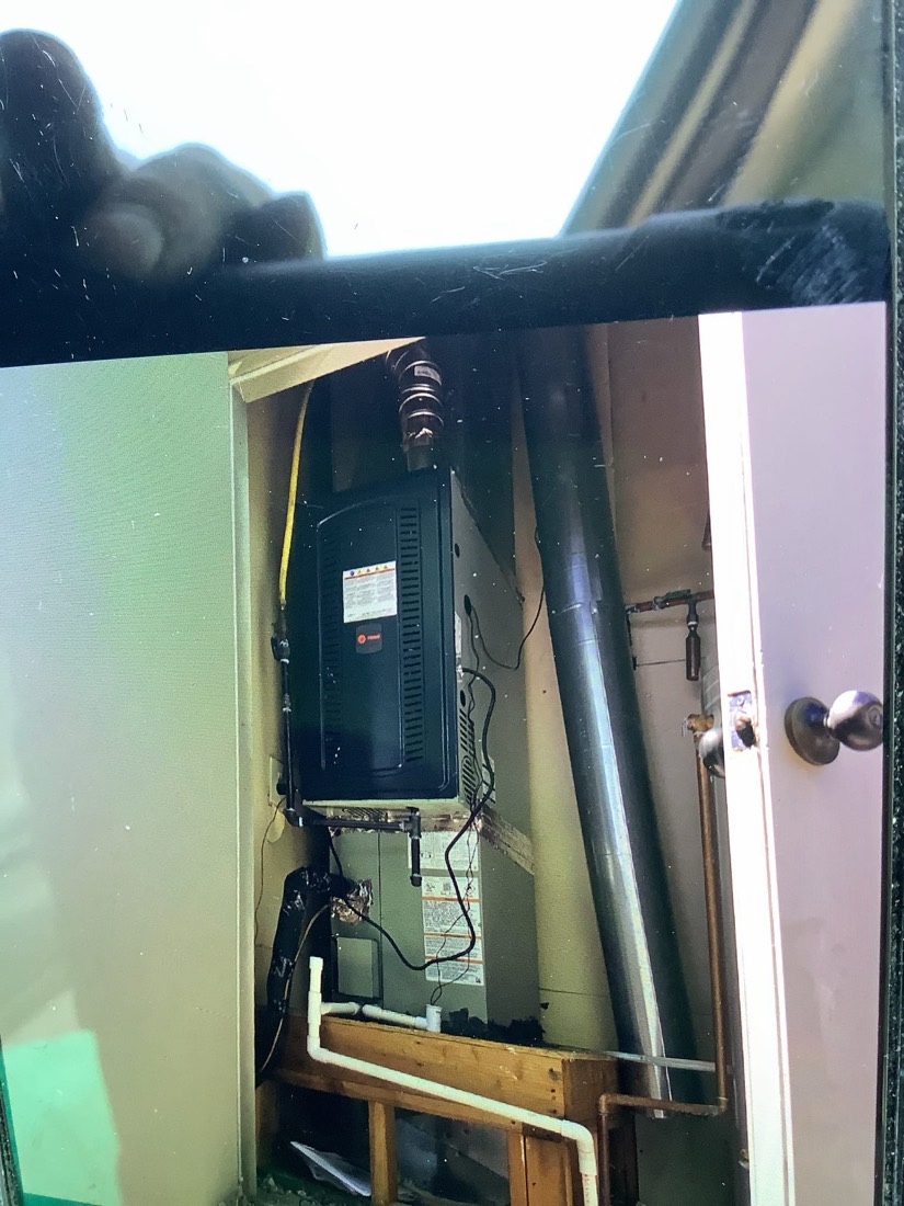 Installed HVAC furnace unit with ductwork and electrical connections in utility closet.