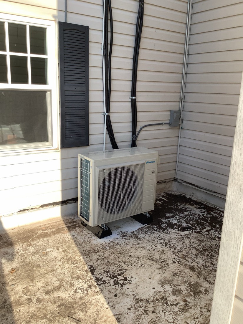 Daikin mini split outdoor condenser unit in enclosure.